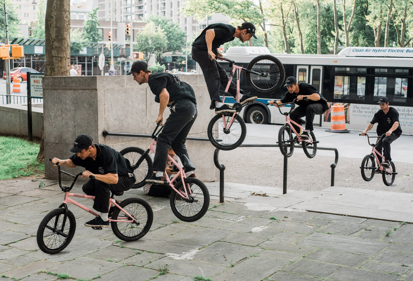 A black bmx bike parked on a concrete path next to a corrugated metal wall, with a "no entry" sign in the background.