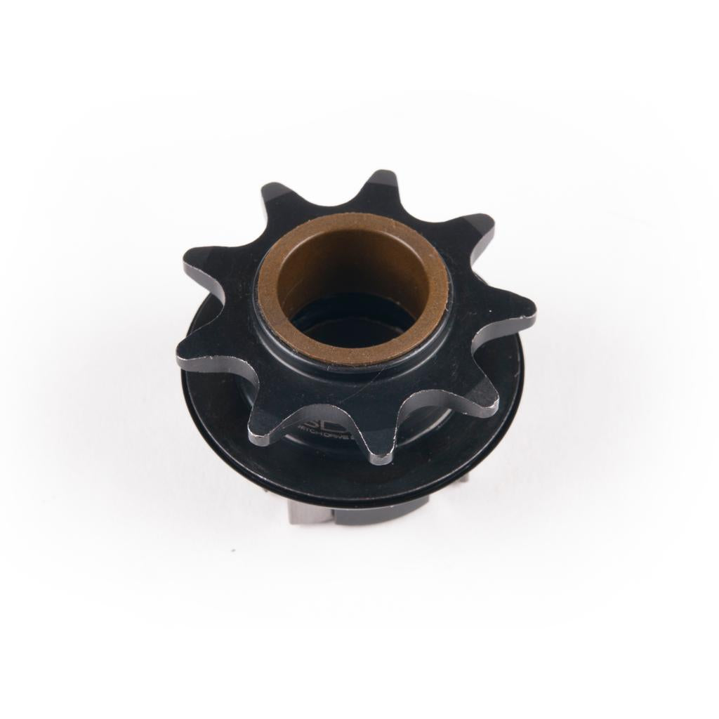 A black metal Eclat Pulse Hub Driver with nine teeth and a brass-colored center bore, photographed on a white background—perfect as a replacement part for your Eclat Pulse hub.