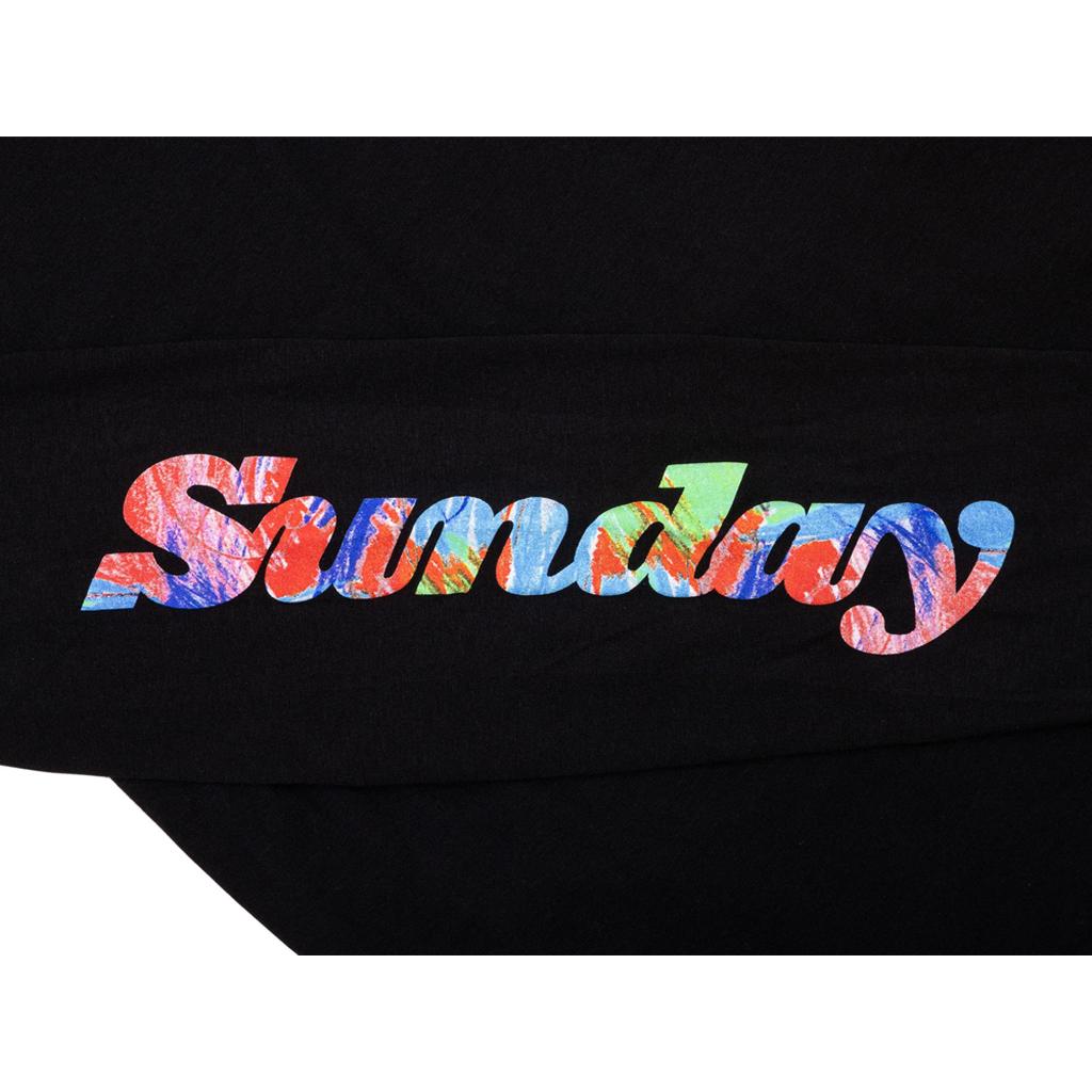 The Sunday Classy Scribble Long Sleeve T-Shirt features "Sunday" in colorful, textured letters on a black fabric—perfect for bold brand statements or adding fun to your back-to-school wardrobe.