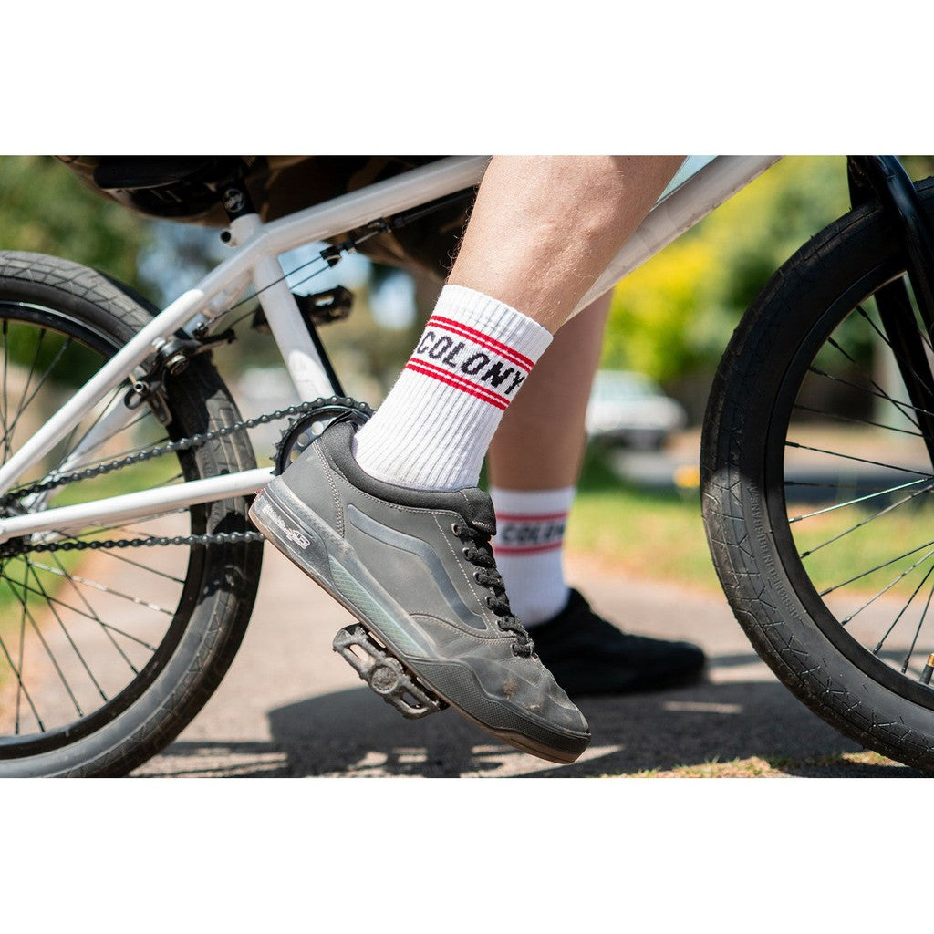 A person on a bike wearing a pair of Colony BMX Logo Socks.