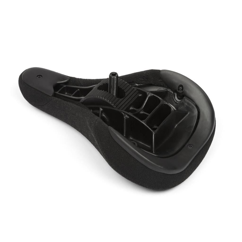 A close-up view of the underside of a black BMX seat, highlighting the mounting bolt and plastic support structure, like those found on the BSD Alvx Eject Pivotal Seat.