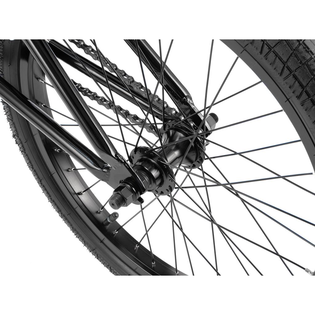 Close-up view of the rear wheel of the Radio Revo Pro FS 20 Inch Bike, highlighting its spokes, axle, tire, chain, and part of the frame against a white background.