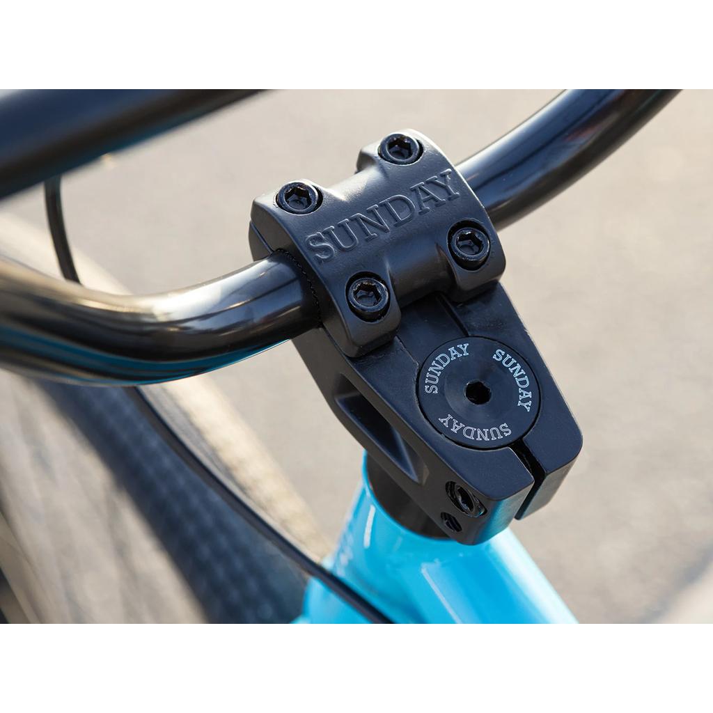 Close-up of a black stem and handlebar with "SUNDAY" branding on a blue chromoly frame Sunday High C 29 Inch Bike (2025) BMX.