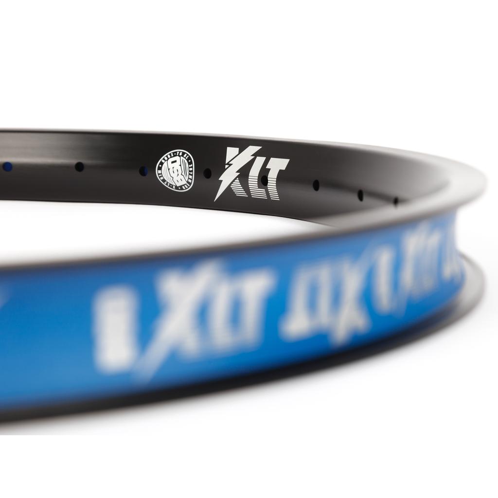 Close-up of the BSD XLT Rim, a durable bicycle rim featuring "XLT" branding and a white logo on its black and blue surface, shown against a white background.