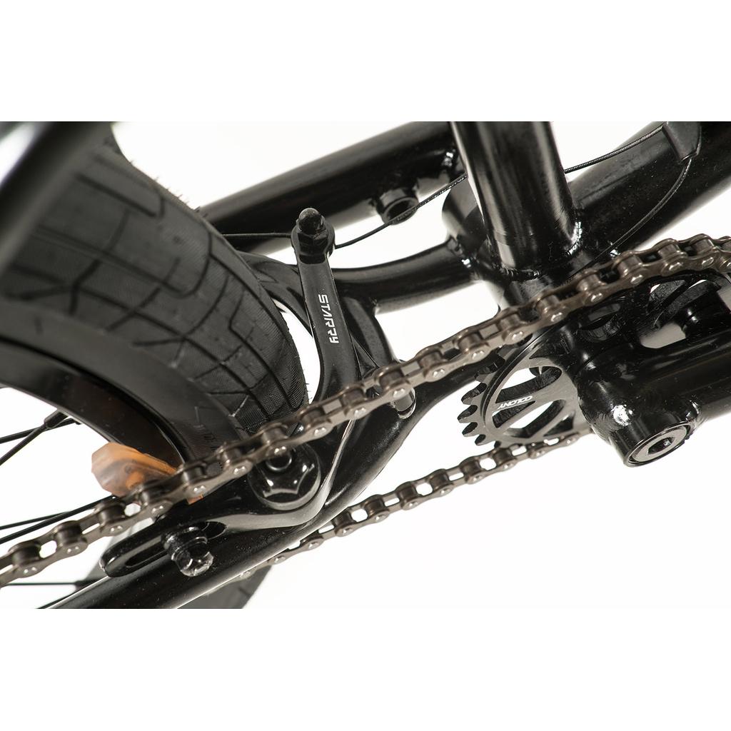 Close-up view of the Colony Prody Pro 20 Inch Bike's black rear wheel, chain, gear, and brake system, highlighting detailed components and tire tread.