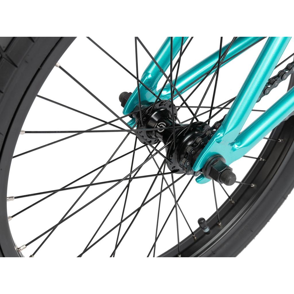 Close-up of the Radio Darko 20 Inch Bike’s rear wheel showing black spokes, teal chromoly frame, axle nuts, part of the tire, and chain—highlighting durable Salt Burn Tyres for superior grip and style.