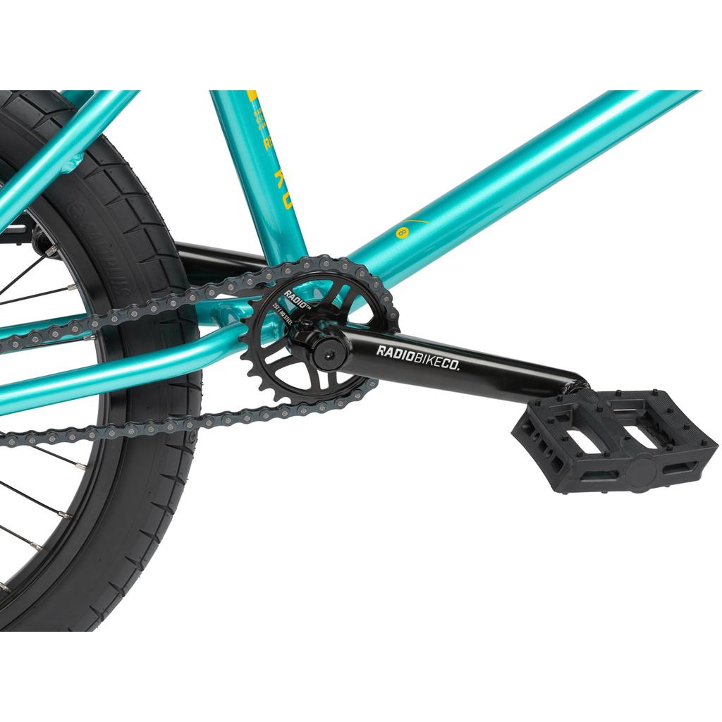 Close-up of the crankset, chain, and pedal on a teal Radio Darko 20 Inch Bike, with RADIOBIKECO branding visible on the crank arm.