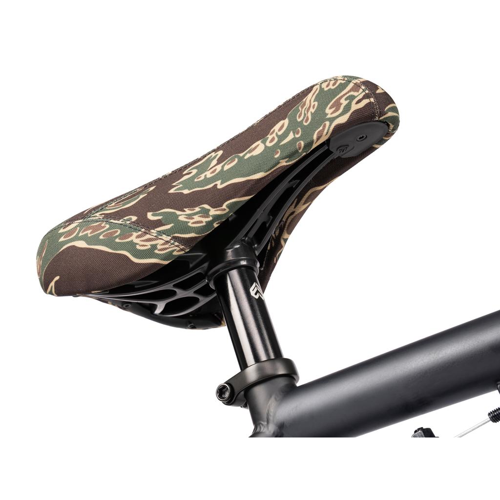 Close-up of a camouflage-patterned seat on a black post, mounted to the matte black Wethepeople Arcade 20 Inch Bike—an ideal choice for riders seeking a solid mid-tier BMX.
