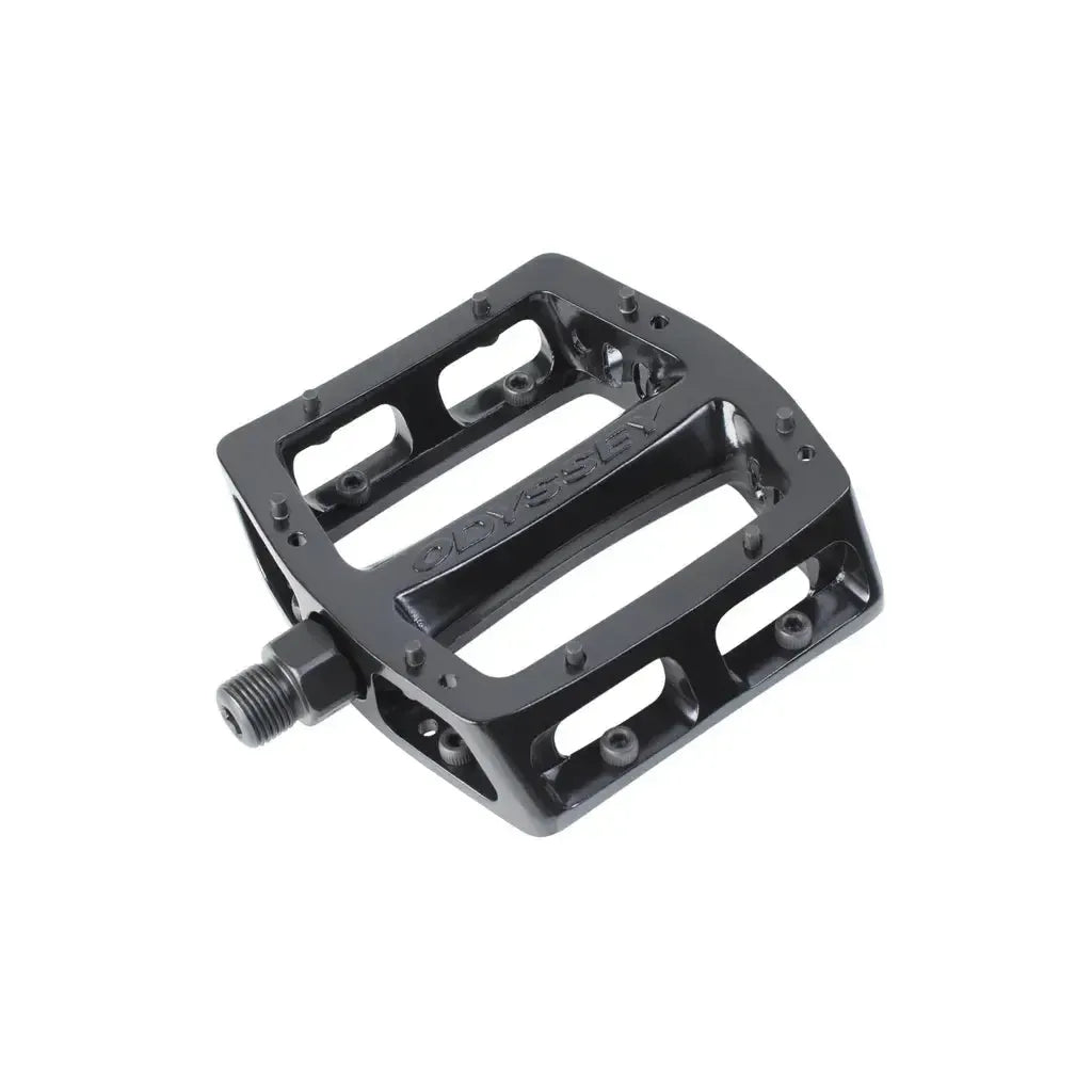 Black metal Odyssey Trailmix Sealed Pedals with a flat, open design, grip pins, and sealed bearings are shown against a white background.