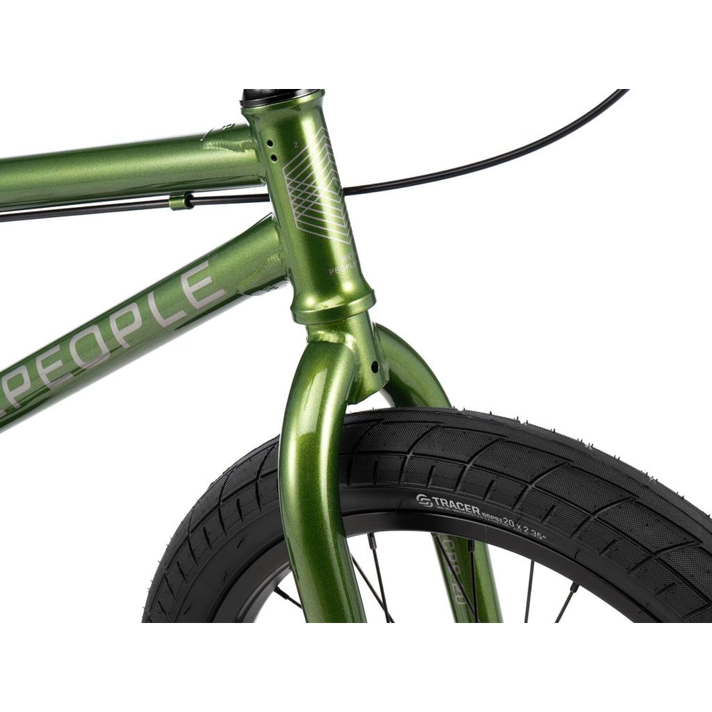 Close-up of the front section of a green Wethepeople CRS 20 Inch Bike, highlighting the fork, tire, part of the frame, and visible brake cables.