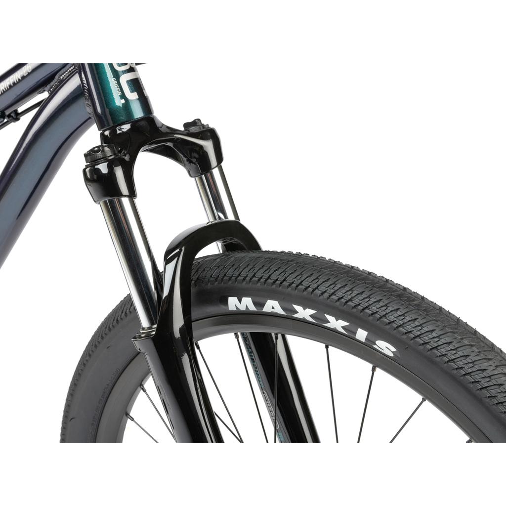 Close-up of the Radio Griffin 26 Inch Bike’s front wheel, equipped with Maxxis DTH tyres, Tektro disc brakes, and a robust front suspension fork.