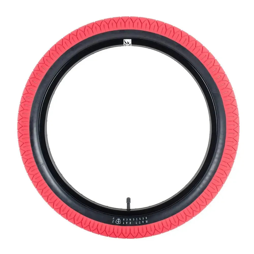 The Subrosa Designer Tyre is a red rubber BMX street tyre with a black inner rim and visible valve stem, shown against a white background—perfect for those seeking Matt Ray signature styling.