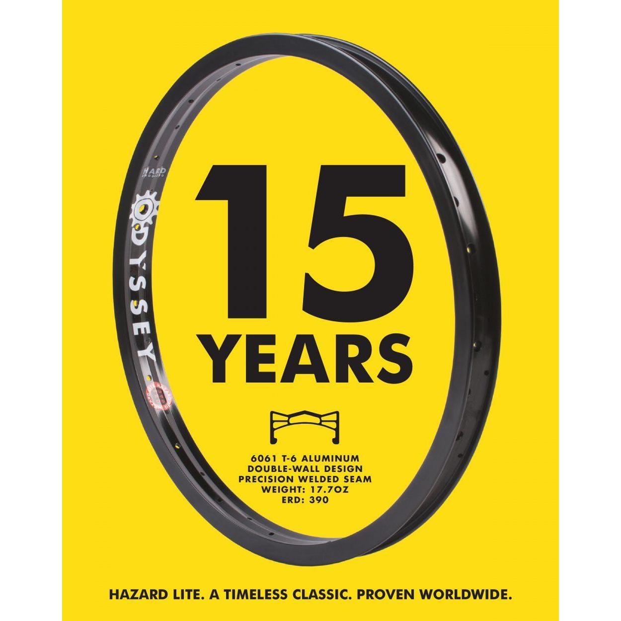 A black Odyssey Hazard Lite Rim, a strong and lightweight BMX rim, is shown on a yellow background with bold "15 YEARS" text. Key specs and the tagline are also featured.