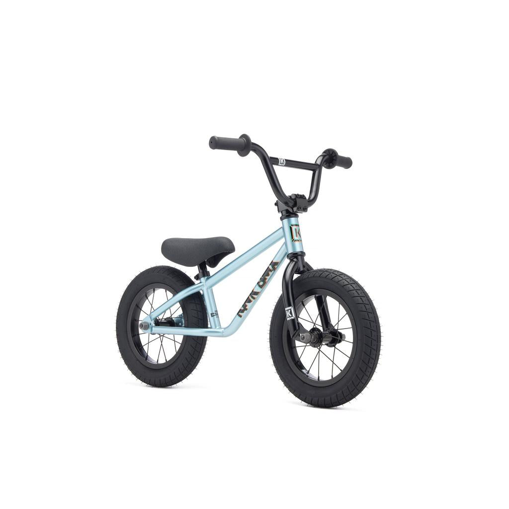The Kink Coast 12 Inch Balance Bike (2027) is a small, light blue kids’ BMX-style balance bike with black handlebars, seat, and 12-inch tyres, shown against a white background.