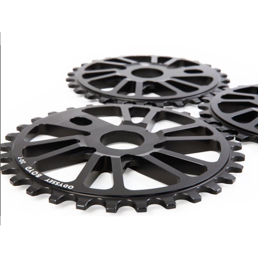 Three black metal bicycle sprockets, including the Odyssey Boyd Sprocket, are arranged on a white surface—ideal for Odyssey BMX enthusiasts.