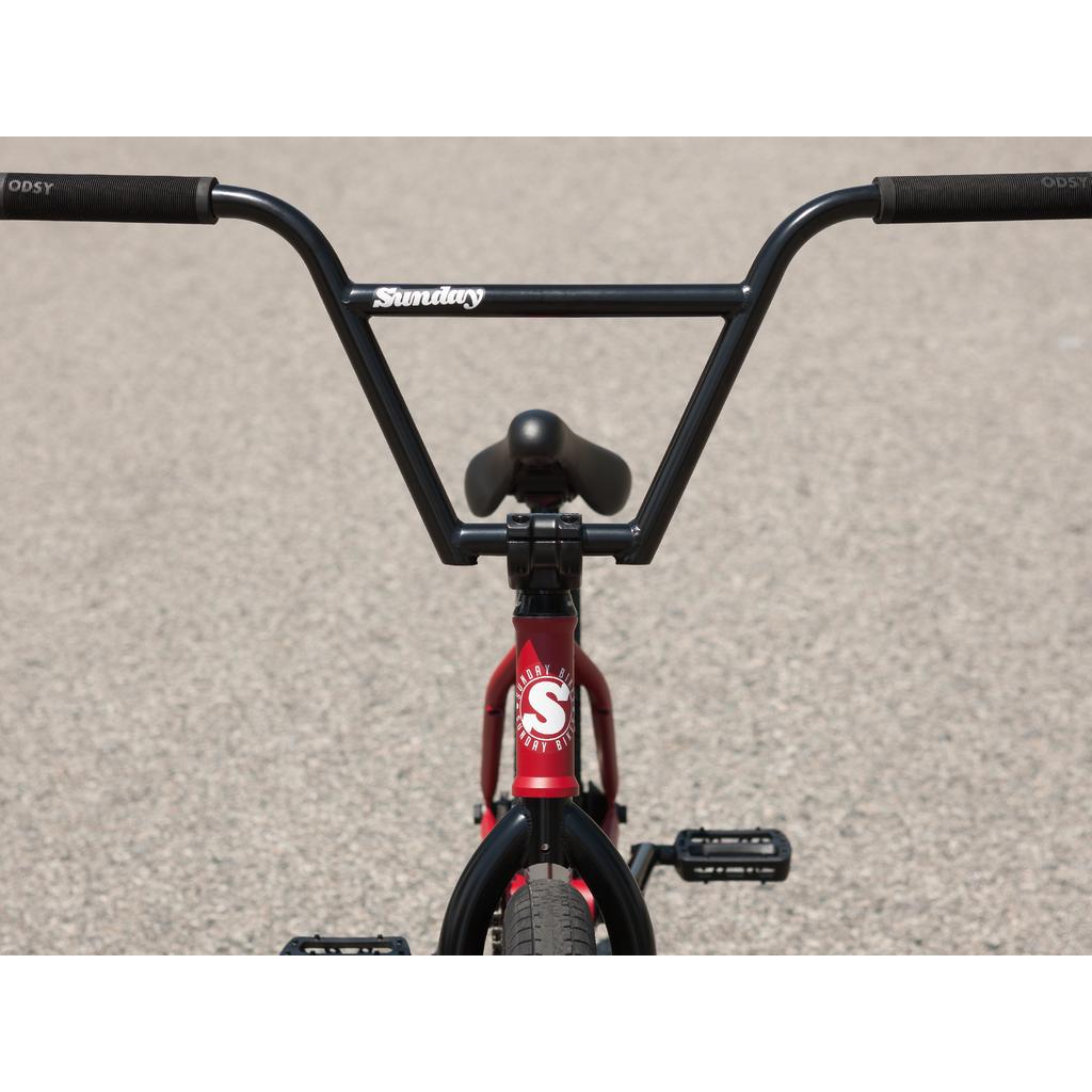 Front view of a red Sunday Forecaster 20 Inch BMX bike with black handlebars, seat, and pedals on a paved surface—built with reliable Odyssey parts for top performance.