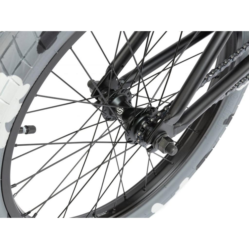 Close-up of a black BMX wheel on the Radio Darko 20 Inch Bike, highlighting spokes, hub, axle, and a gray Salt Burn Tyres tire with a white tread pattern.