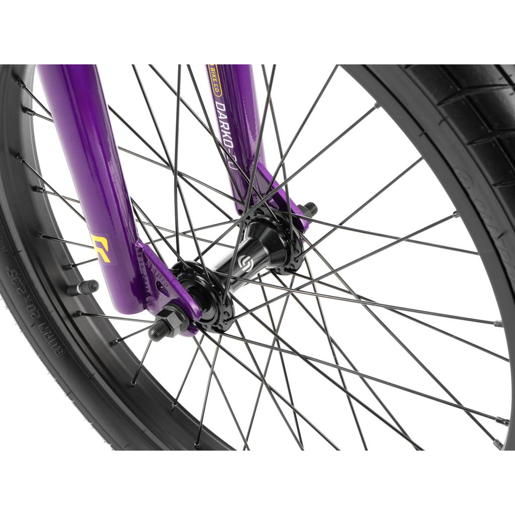 Close-up of the Radio Darko 20 Inch Bike’s front wheel with black spokes, a black hub, a purple fork labeled "DARKO," and durable Salt Burn Tyres.
