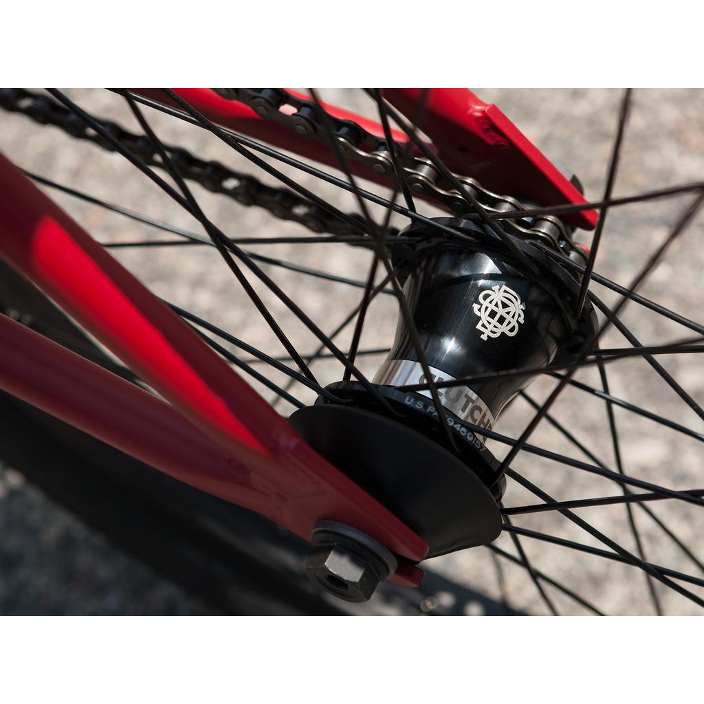 Close-up of a bicycle rear wheel hub with black spokes and chain, showing the manufacturer's logo on the hub, attached to a red chromoly Sunday Forecaster 20 Inch Bike.