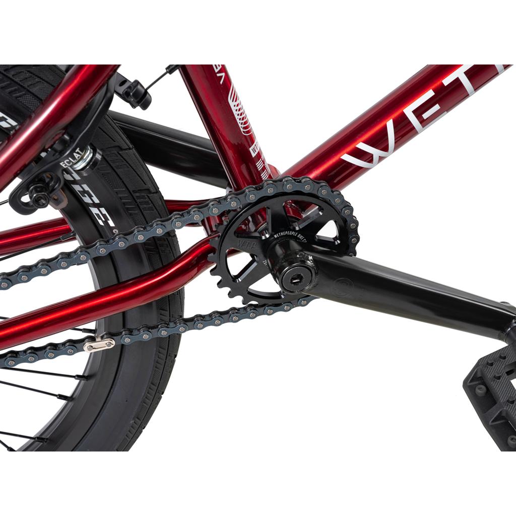 Close-up of the Wethepeople Versus 20 Inch Bike drivetrain featuring the chain, chainring, crank arm, pedal, and rear wheel—ideal for skatepark BMX enthusiasts.