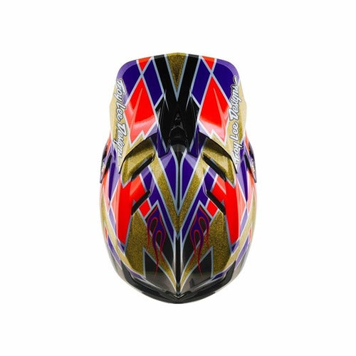 Top view of the TLD 26.2 D4 Carbon Full Face Helmet / MIPS Flush Violet, showcasing bold geometric patterns in purple, red, gold, and black with “Troy Lee Designs” text on both sides. This downhill helmet delivers standout style along with advanced Mips protection for enhanced safety.