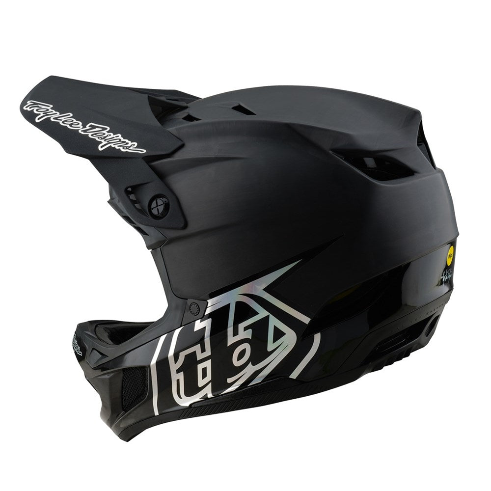The TLD 25.2 D4 CARBON HELMET MIPS STEALTH BLACK is a matte black full-face helmet with white geometric graphics, visor, Mips protection, and vent openings—perfect for downhill mountain biking; shown in side view.