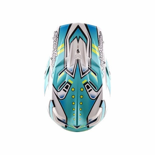 Top view of the TLD 26.1 D4 AS Composite Helmet in Crest Real Teal, featuring blue, teal, and white geometric patterns, "Troy Lee Designs" text on both sides, and a Mips system for enhanced safety.