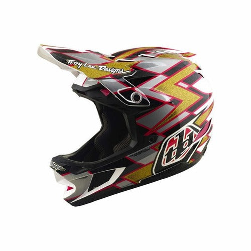 The TLD 26.2 D4 Composite Helmet / MIPS Flush Black is a black, red, and gold mountain bike full-face helmet with angular graphic patterns and “Troy Lee Designs” logos on the visor and side, featuring advanced MIPS protection for enhanced safety.