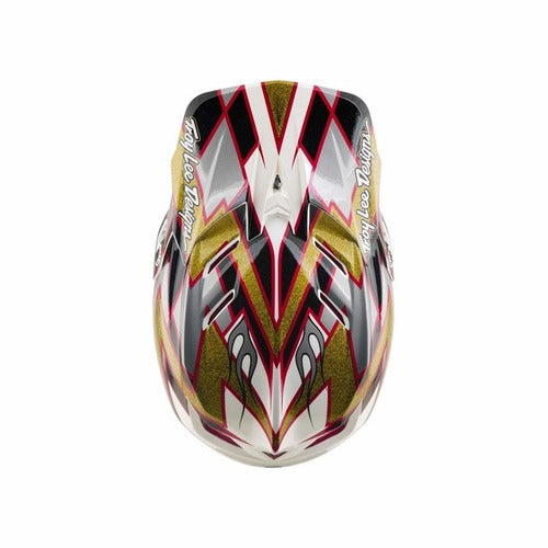 The TLD 26.2 D4 Composite Helmet / MIPS Flush Black is a motocross full-face helmet adorned with red, black, white, and gold angular patterns visible from above. It features “Troy Lee Designs” text on each side and is equipped with integrated Mips protection for added safety.