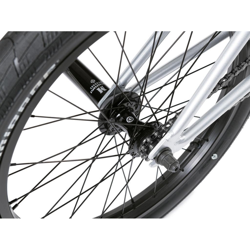 Close-up of the rear wheel, tire, metal spokes, hub, and axle of the Wethepeople Versus 20 Inch Bike against a white background.
