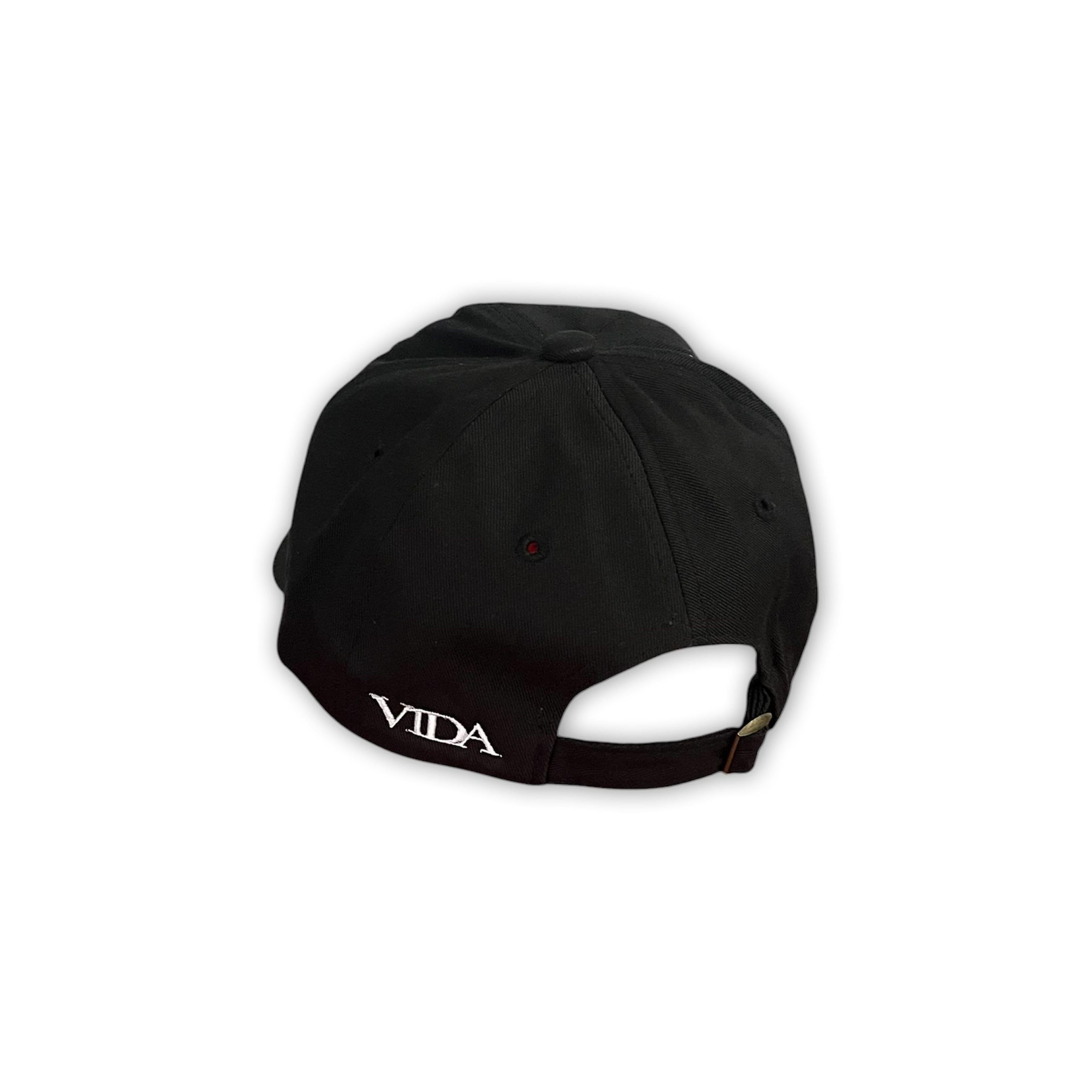 V1da The Dad Cap, shown from the back, features "VIDA" embroidered in white above the adjustable strap. This unstructured black hat offers a classic, low-profile fit.