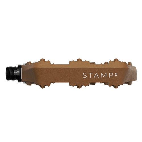 Side view of a brown Crank Brothers Stamp 0 Pedals (Large) with grip pins visible and "STAMP 0" text on the concave platform.