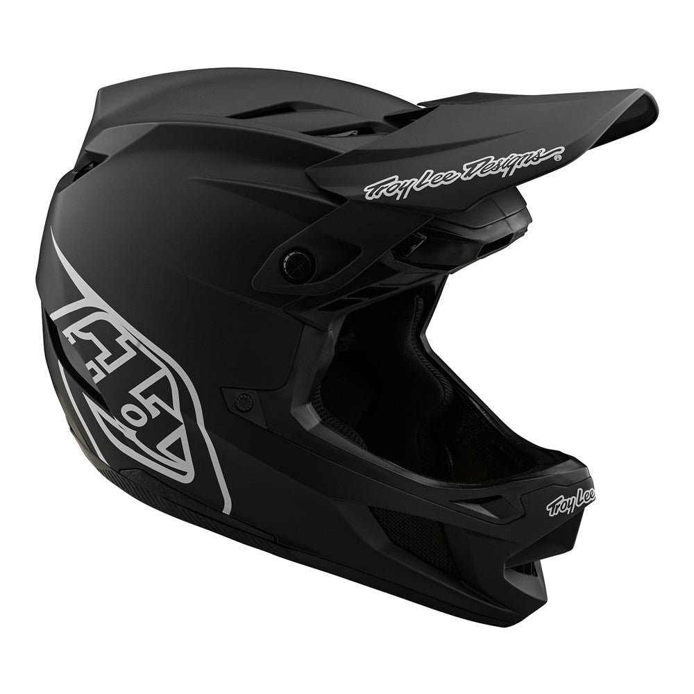 The TLD D4 AS Polyacrylite Helmet W/MIPS Stealth Black features a matte black finish with white Troy Lee Designs logos, large visor, and multiple ventilation openings for full-face protection.
