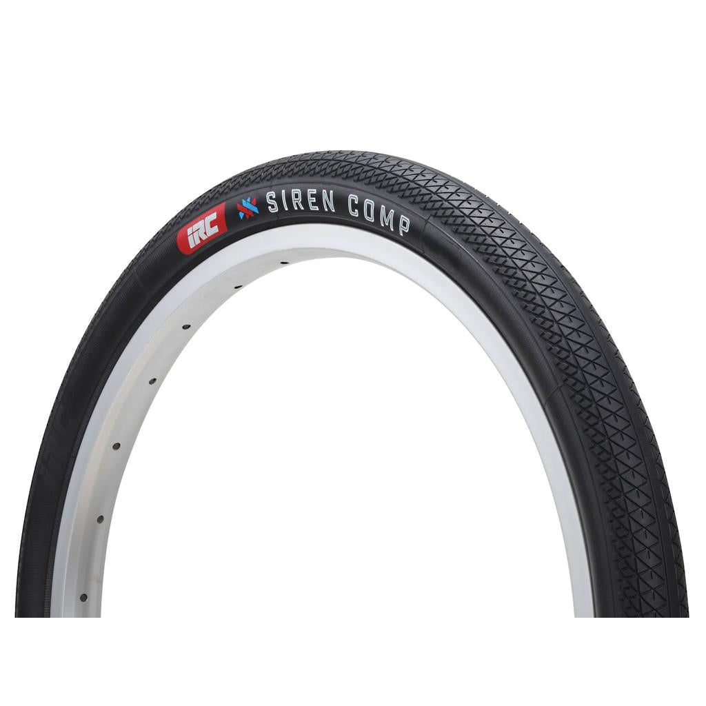 A close-up of the IRC Siren Comp 20 Inch Tyre in black, featuring a patterned tread, aramid bead, and mounted on a white rim against a plain white background.