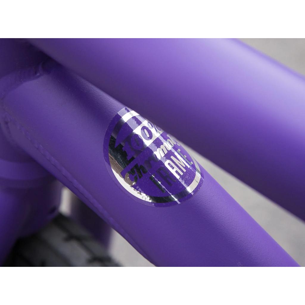 Close-up of the Sunday Forecaster 20 Inch Bike in purple, showcasing a metallic "100% Chromoly Frame" sticker label that highlights the bike’s strength and style.