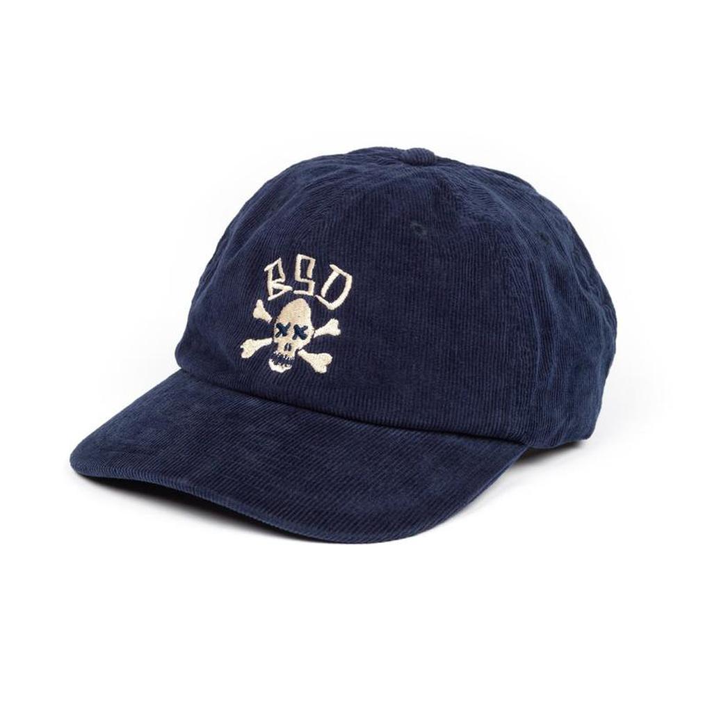 The BSD More Speed Cap is a navy blue corduroy 6-panel cap with a white skull and crossbones on the front and "BSD" embroidered above the skull.