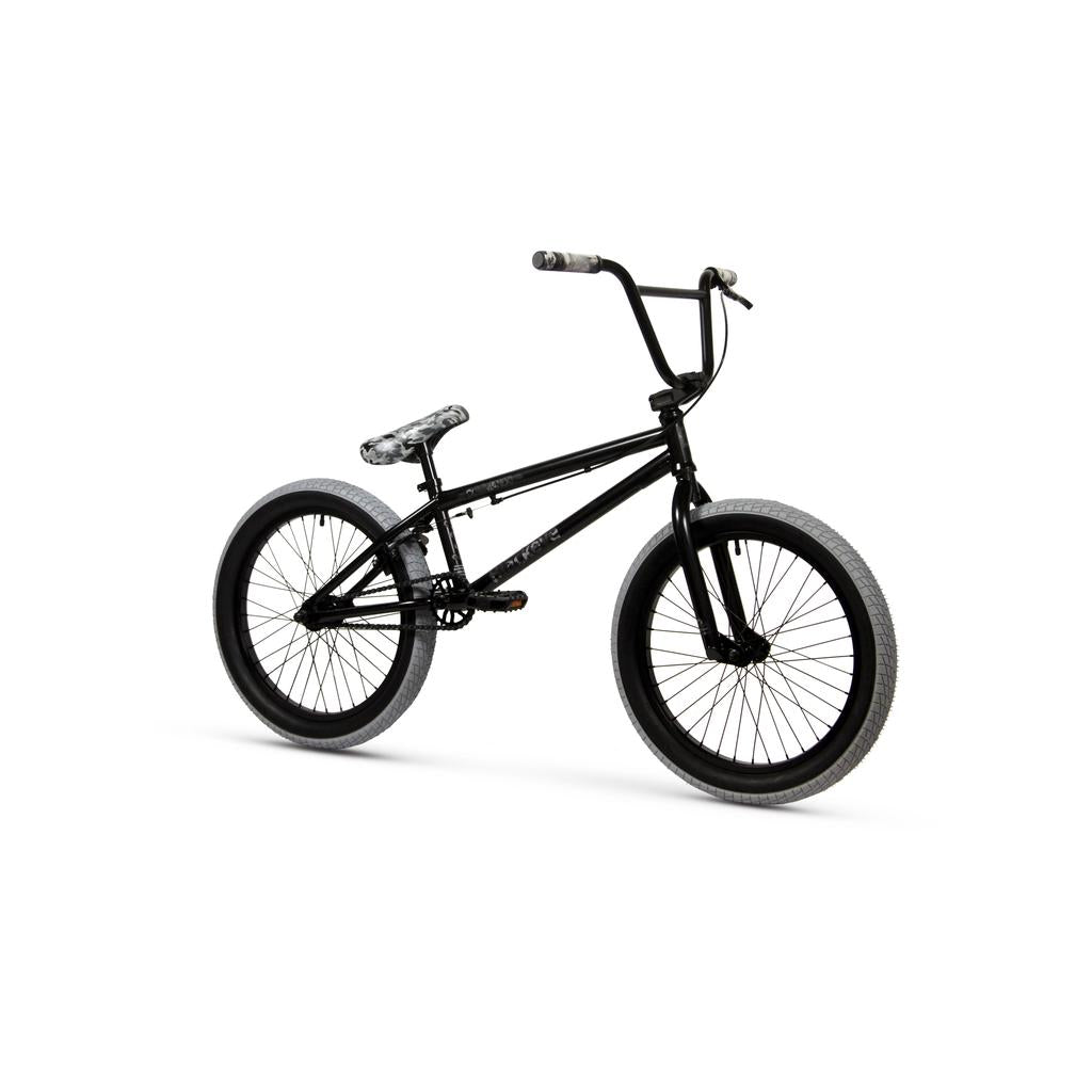 The Black Eye Commando 20 Inch Bike (2022) is an entry-level BMX with gray tires, black handlebars, and a patterned black-and-white seat, all showcased on a white frame.