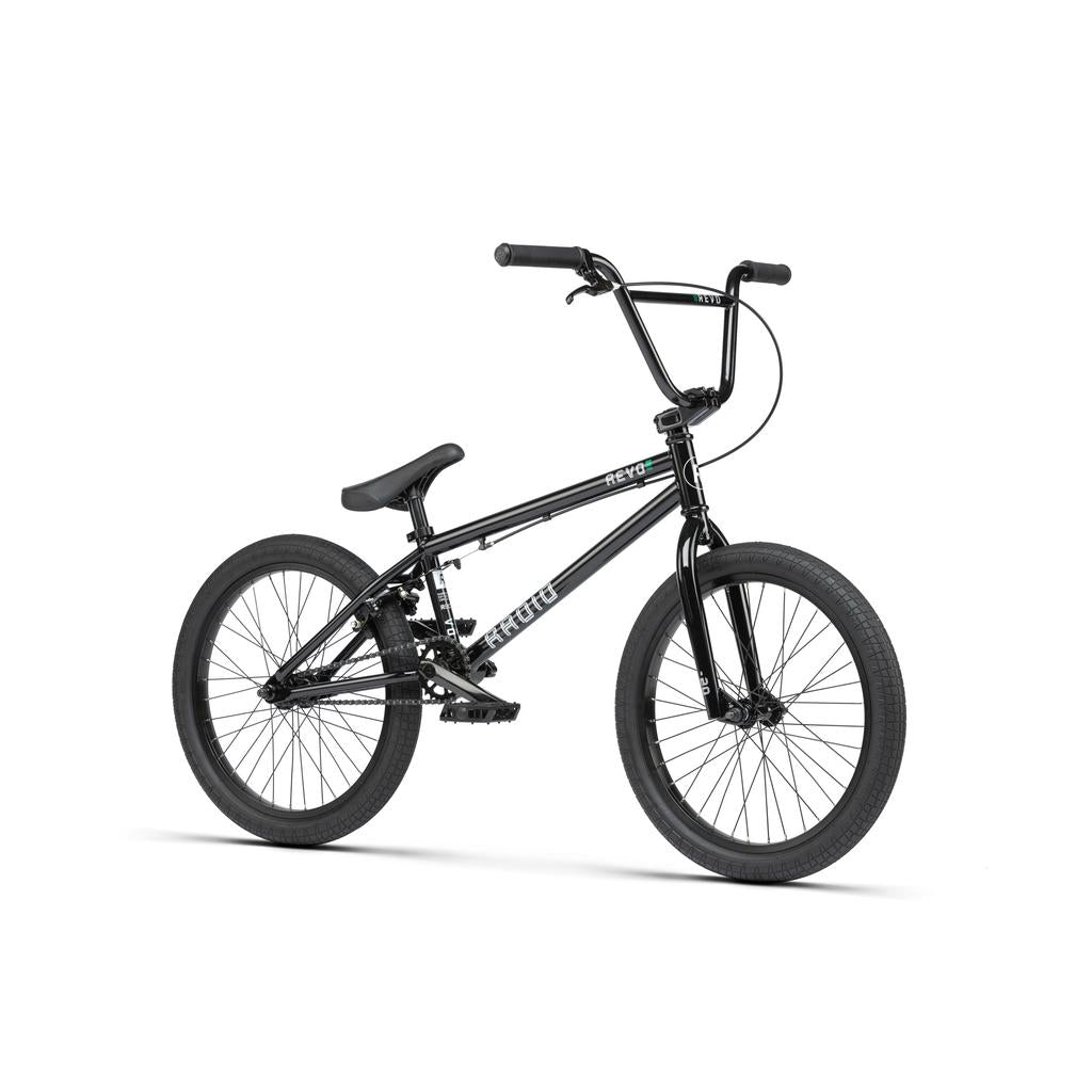 The Radio Revo Pro 20 Inch Bike, shown on a white background, features a black compact frame, thick tires, flat pedals, straight handlebar, and durable Radio Rookie Three Piece Cranks for enhanced performance.