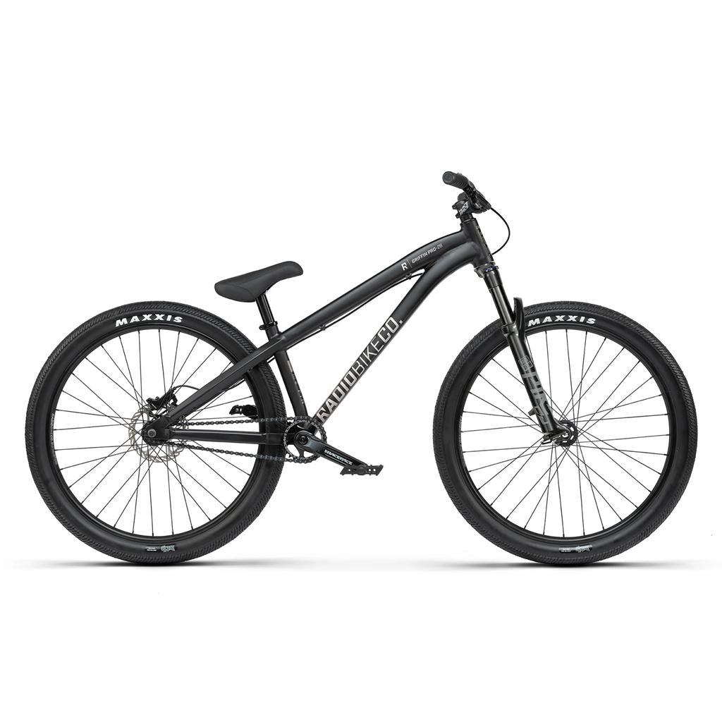 A matte black Radio Griffin Pro Elite 26 Inch Dirt Jumper Bike with Rock Shox Pike DJ front suspension, disc brakes, and Maxxis tires is shown from the side against a white background.