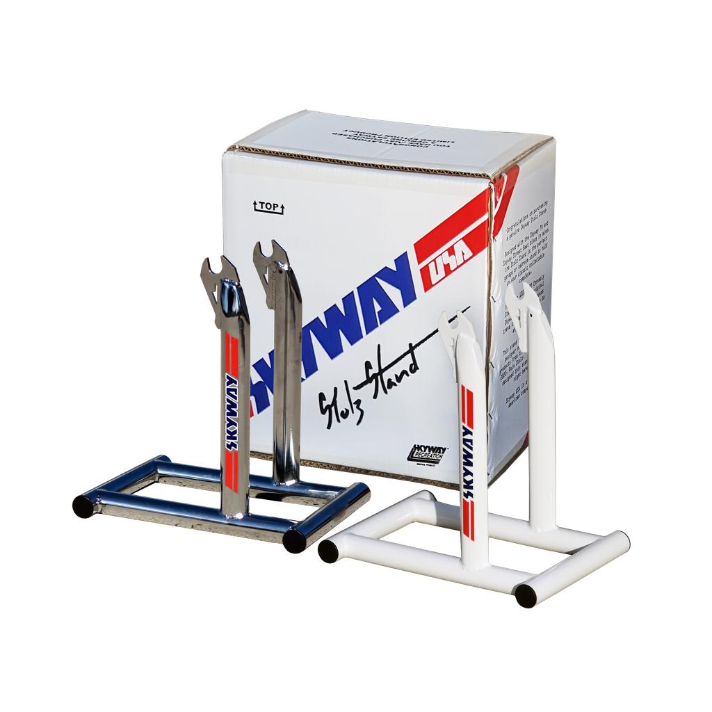 Two Skyway Stolz Stands with "Anway USA" branding are displayed in front of a matching branded box on a white background, ideal for showcasing your TA Replica bike.
