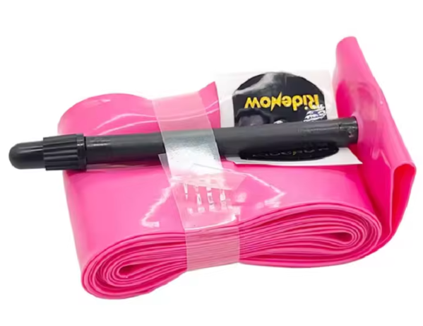 A RideNow TPU 24 Inch Tube with a Presta (Car) valve, rolled up and secured with clear tape, features a pink ultra-lightweight construction and black valve stem, displayed against a white background.