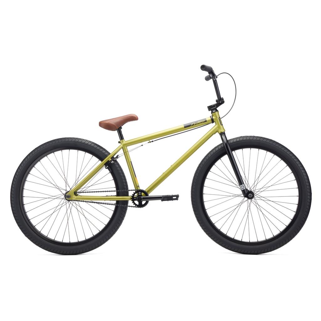 The Kink Drifter 26 inch Bike (2027) features a yellow frame, large black tires, a brown seat, and straight handlebars, all set against a white background with its sturdy chromoly build standing out.