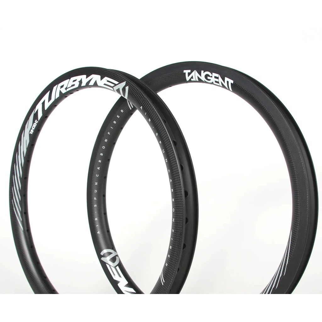 Two black Tangent Turbyne Carbon Brakeless Rim 406mm rims, crafted from high modulus carbon fibre, feature white text "TURBINE" on the left rim and "TANGENT" on the right rim, displayed against a plain white background.