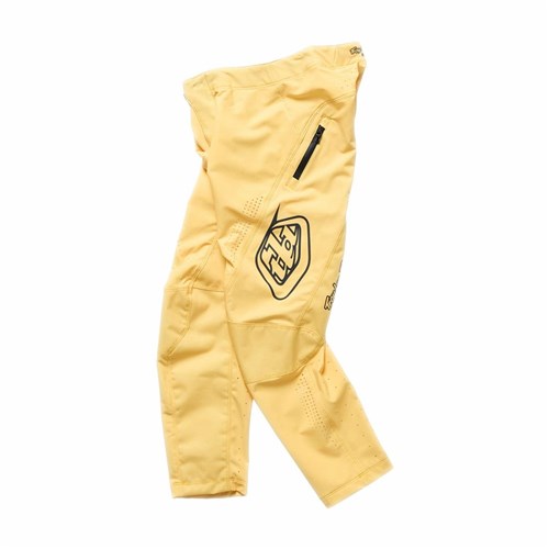 A pair of TLD 26.1 Sprint Pro Pants (Youth) in Mono Butter, featuring a zippered pocket and black logo, made from 4-way stretch fabric for comfort and durability, laid flat on a white background.
