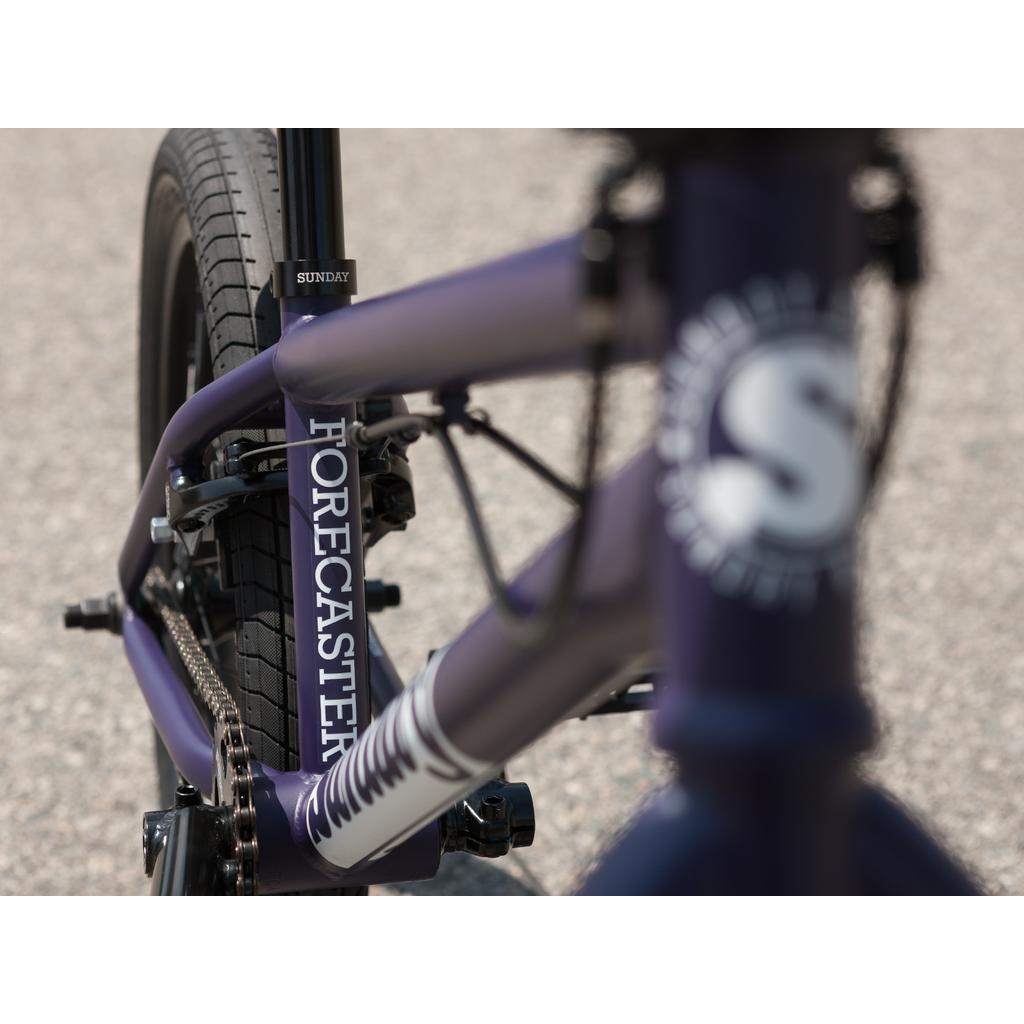 Close-up of the Sunday Forecaster Maca Grasset 20 Inch Bike frame showing "FORECASTER" and "SUNDAY," plus the rear wheel, chain, and gyro—ideal for any BMX park rider.