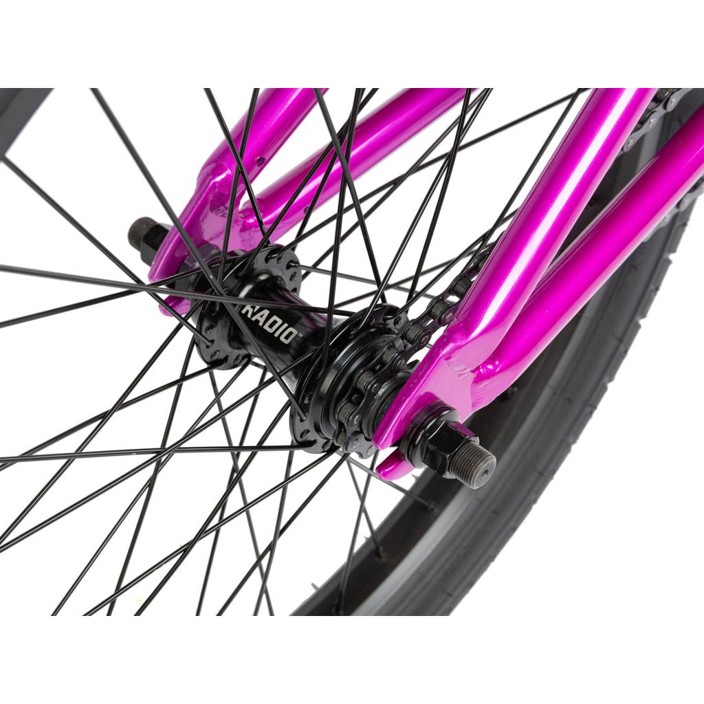 Close-up of the Radio Saiko 20 Inch Bike wheel, featuring black spokes, a black Radio hub, Salt Tracer Tyres, and a metallic pink fork—showcasing stylish details for an eye-catching kids BMX.