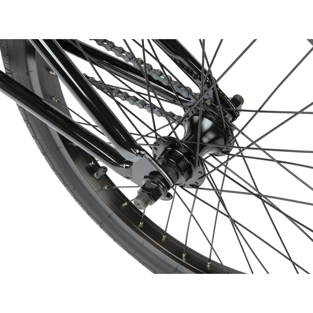 Close-up of the rear wheel on the Radio Revo Pro 20 Inch Bike, highlighting its black spokes, hub, axle, chain, and tire against a white background.