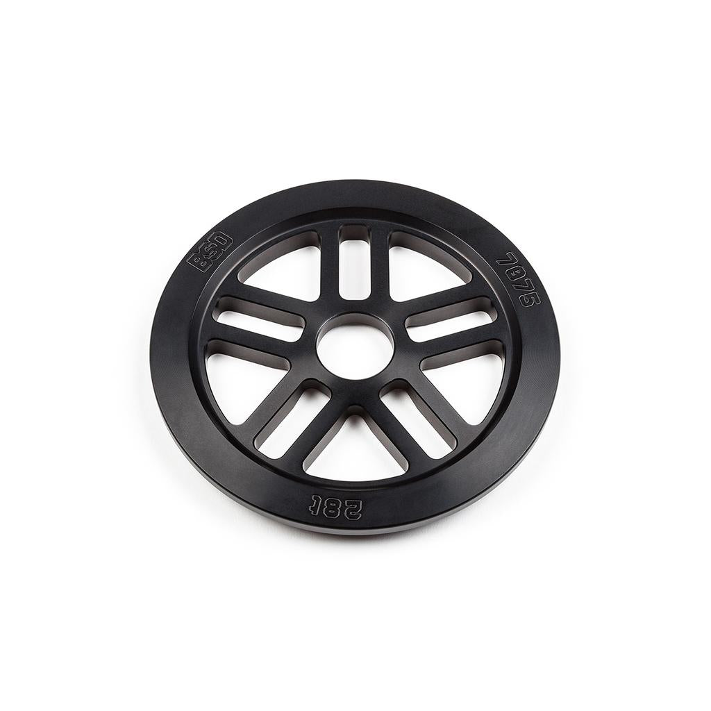 The BSD Guard Sprocket is a black metal circular sprocket with eight spokes, a central hole, and rim engravings reading "65D," "7075," and "28T.