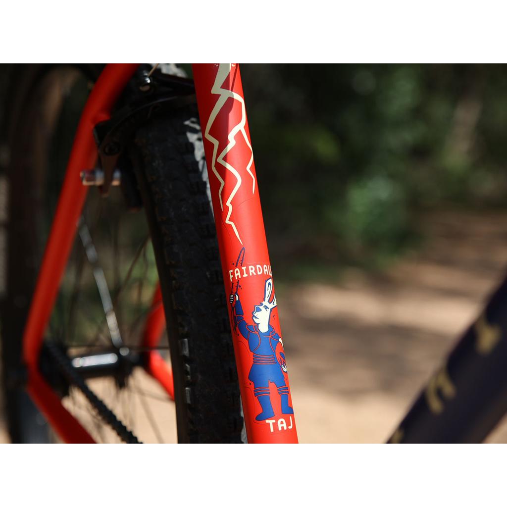 Close-up of the 2023 Fairdale Taj 27.5 Inch Bike frame with a white rabbit in armor graphic, "FAIRDAL" and "TAJ" on the fork—showcasing this striking BMX-inspired commuter and single speed bike.