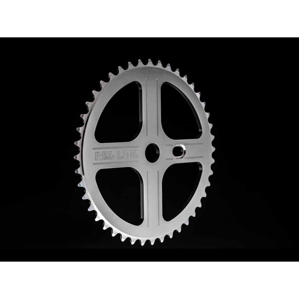 A silver metal chainring with four spokes and "RED LINE" engraved, designed for the Redline Vintage Flight 401 Crank Set, displayed against a black background.